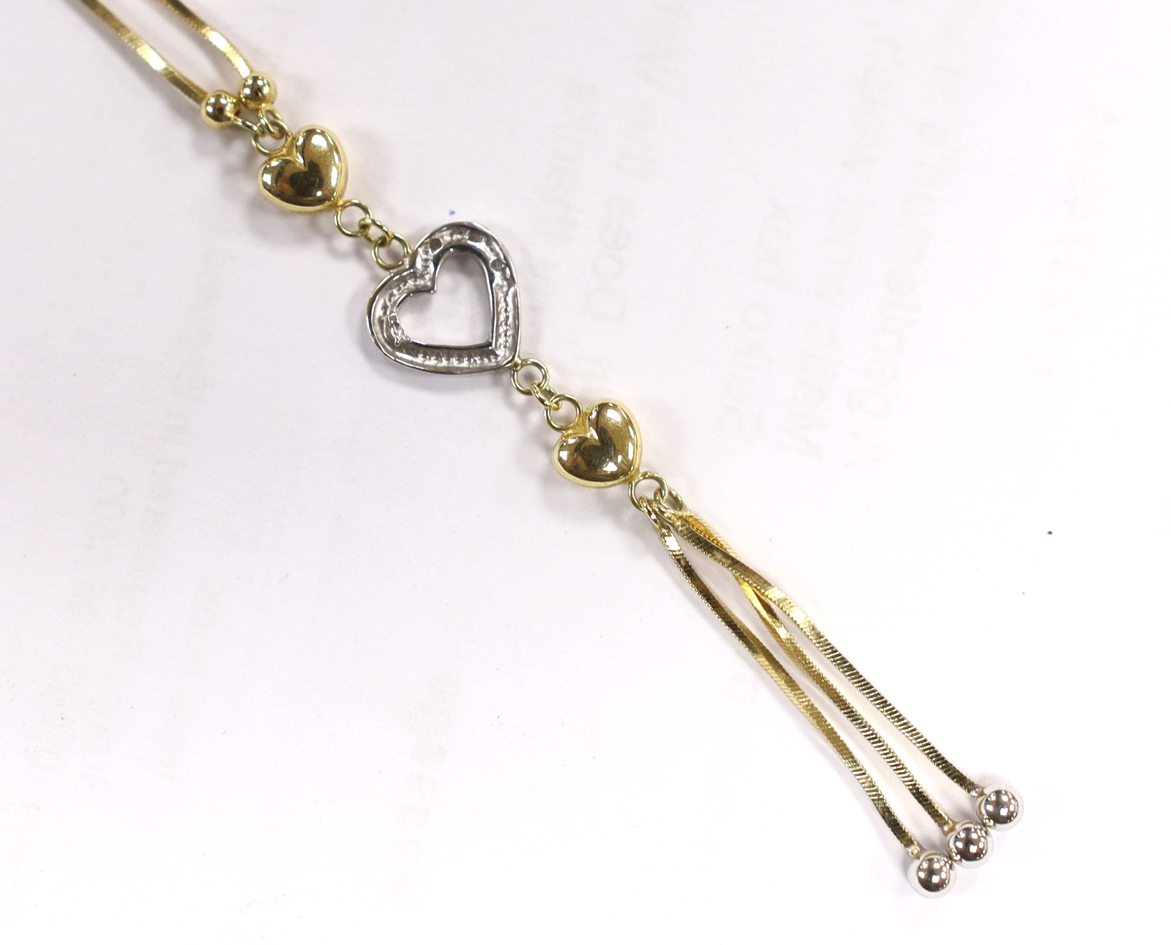 A modern two colour 14k and three white stone set heart drop tassel necklace, 56cm, gross weight, 4.7 grams.